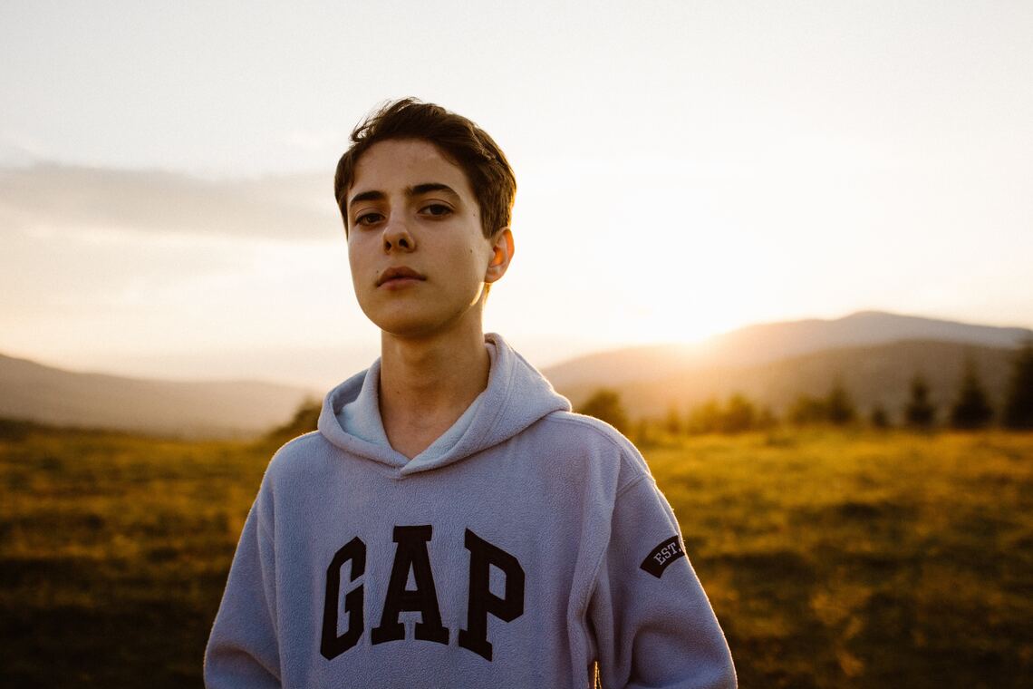 A young man in front of a sunset